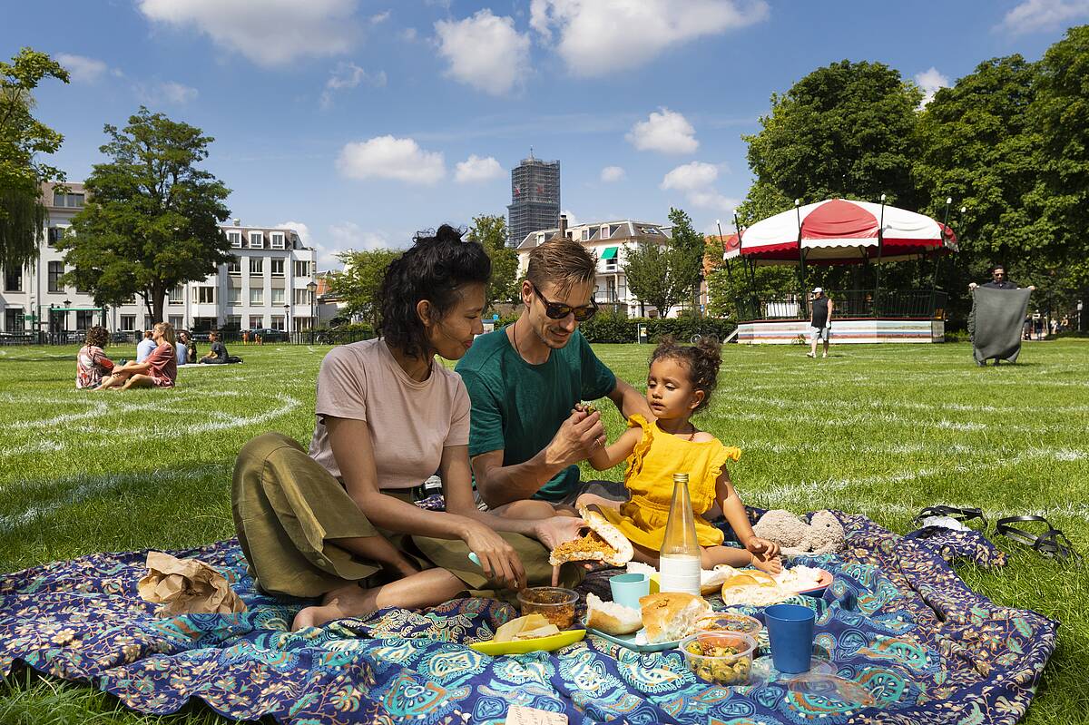 A family is having a picnic in Lepelenburg Park on a sunny day.