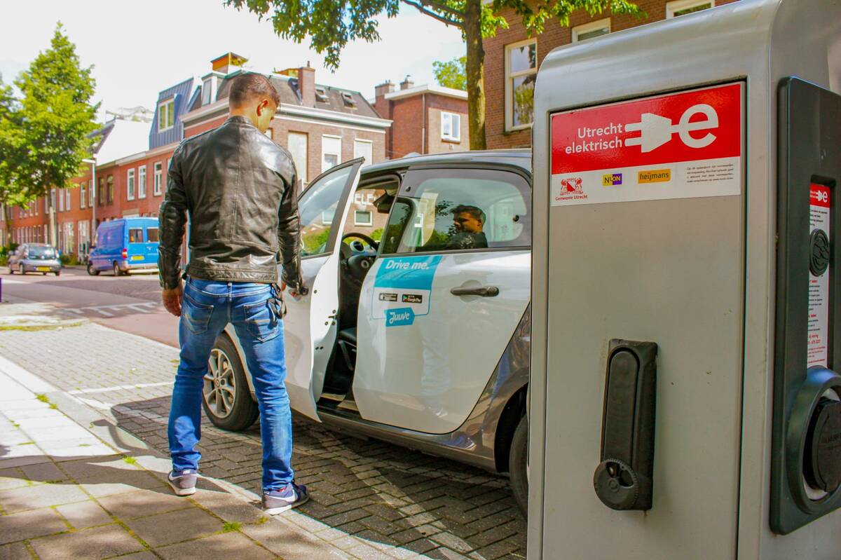 A man charges an electric car.